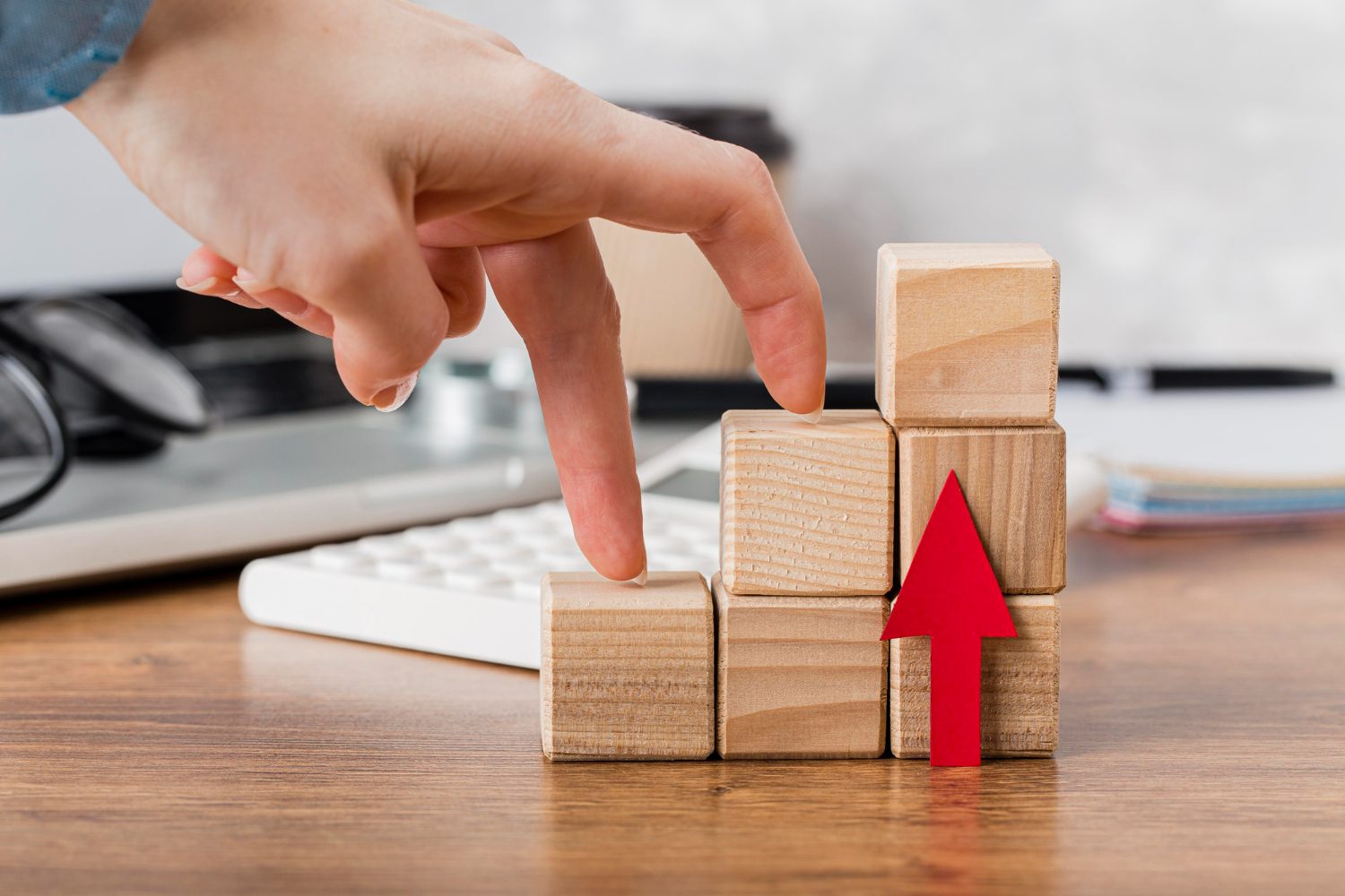 hand climbing wooden blocks to represent growth